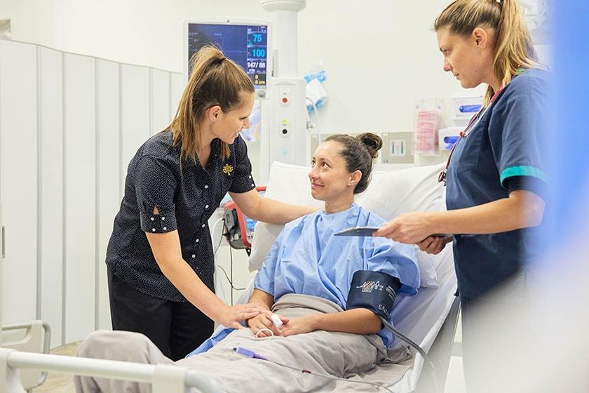 A Precina care-team member visiting a patient at their bedside